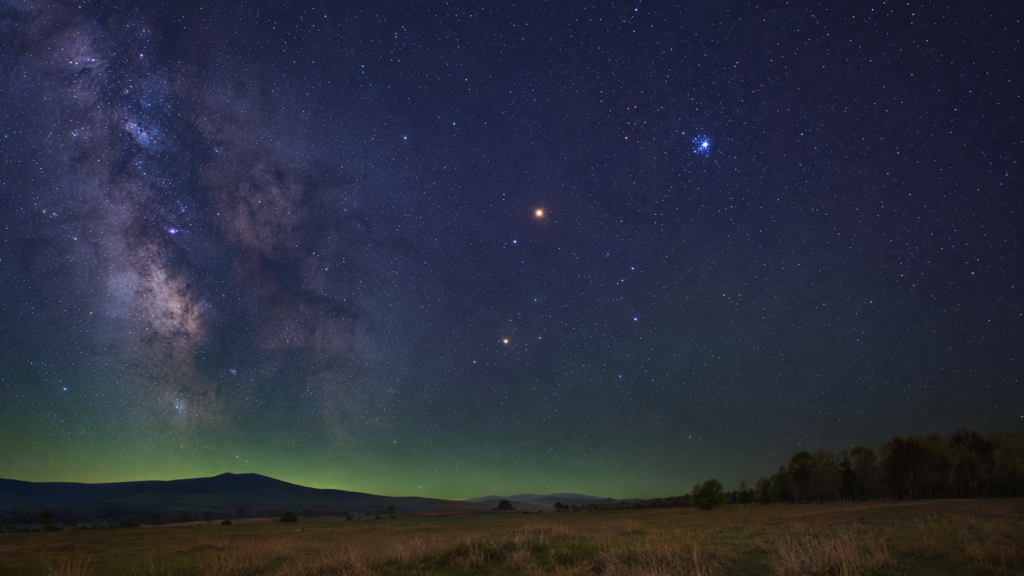 Byk - gwiazdozbiór znaku zodiaku Byk z pomarańczową gwiazdą Aldebaran i gromadą Plejad na nocnym niebie